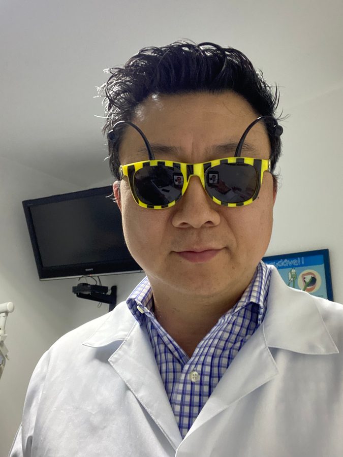 Dr. Wagner Okai no consultório, usando óculos divertidos de criança