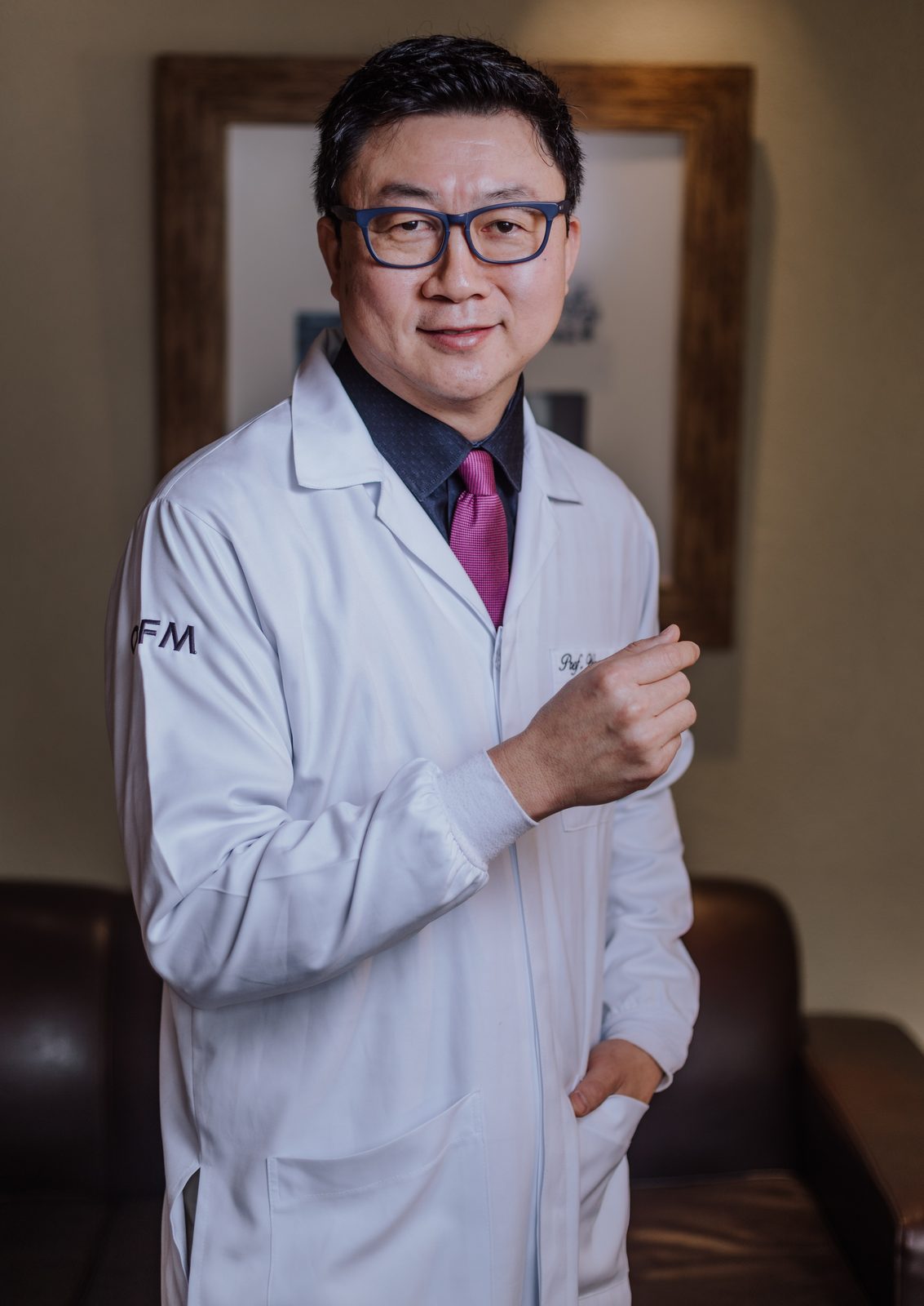 Dr. Wagner Okai, cirurgião-dentista, de jaleco branco e gravata, sorrindo