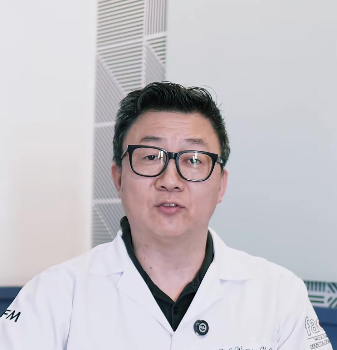 Dr. Wagner Okai, cirurgião-dentista, de jaleco branco e óculos